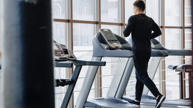 stylish guy in the gym is training on the treadmill. Healthy Lifestyle. wellness.